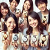 A group of Japanese people happily holding their new high-end metallic luxury wristwatches. They are smiling and proudly showing off the watches in their hands. The background is modern and elegant, reflecting their joy and satisfaction of finding their favorite timepieces. No brand logos visible.